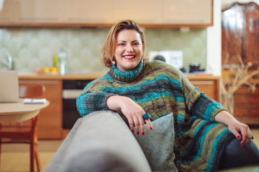 Woman sitting on a couch smiling at her skincare coach during a face to face consultation where they're planning a personalised skincare program